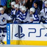 Spencer Abbott receiving high fives from the rest of the Toronto Maple Leafs team.