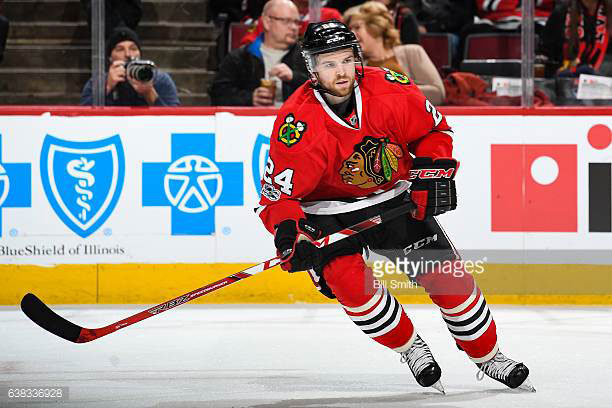 Spencer Abbott skating down the hockey rink in mid-stride in his Chicago Blackhawk jersey.
